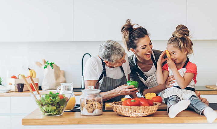 Three generations of women in a kitchen cooking together