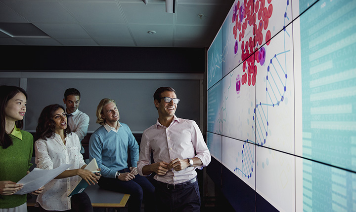 A group of people looking at a large interactive display