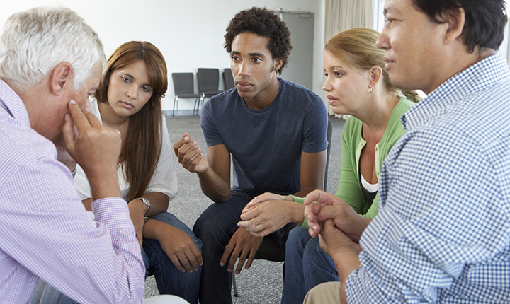 A diverse group of people sitting in a counselling session