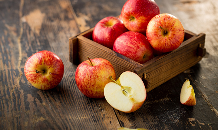 A wooden box filled with gala apples 