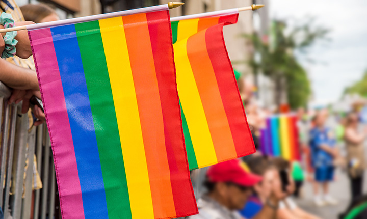 Rainbow flags along the side of a pride parade route