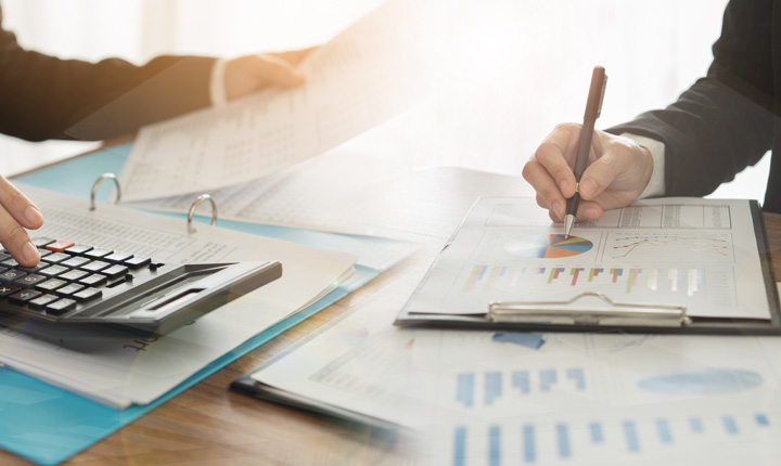 People sitting at a table reviewing financial statements and graphs