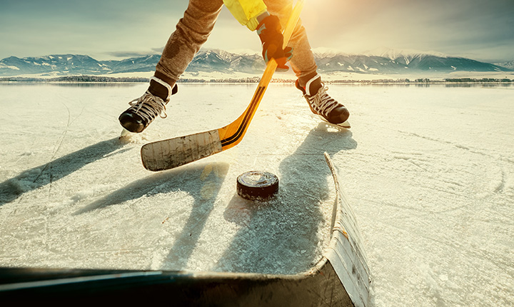 Hockey players sticks and legs in a pond hockey face-off