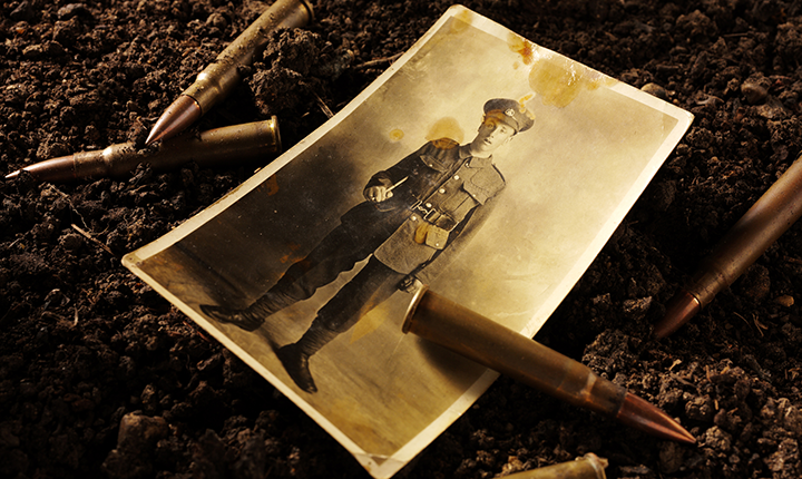 Sepia image of bullets and photo of soldier on ground