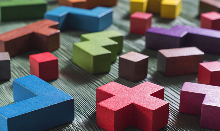 Colourful wooden blocks scattered on a grey wooden surface