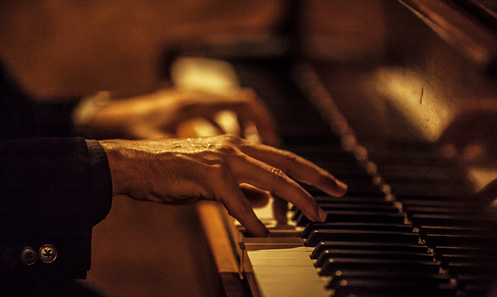 Hands playing a piano