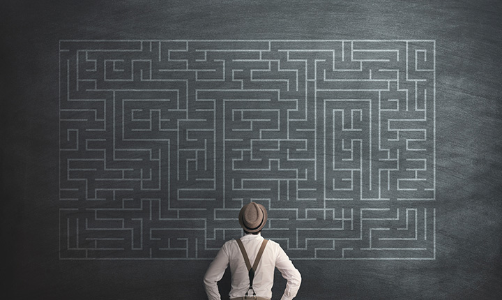 Person staring at a labyrinth on a chalkboard