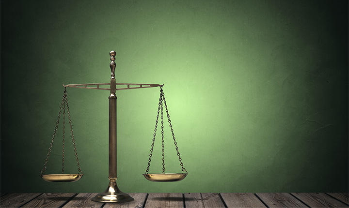 Balanced scales of justice on a green background