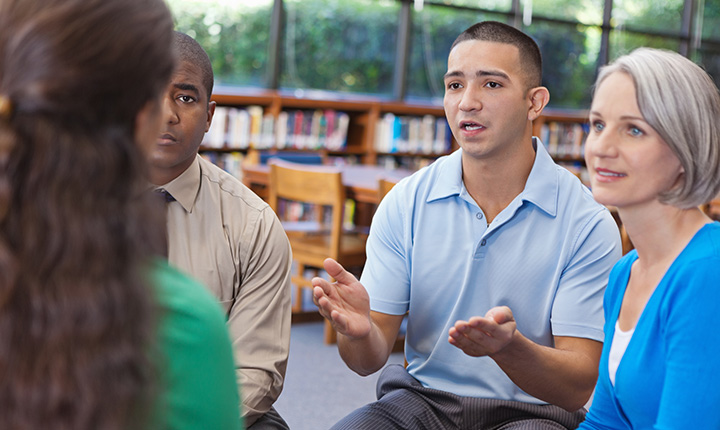 Diverse people having discussion in a group support meeting