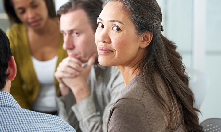 Woman smiling while interacting in a group discussion